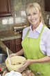 Portrait of a happy senior woman preparing food in kitchen