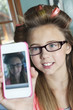 Photo: Little girl with hair curlers photographing herself with cell phone Little girl with hair curlers photographing herself with cell phone