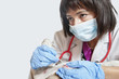 Photo: Female veterinarian cleaning injury on dog's leg with stick bud over gray background Female veterinarian cleaning injury on dog's leg with stick bud over gray background
