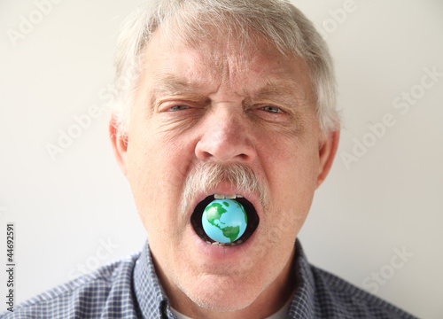 Photo: man with earth model in his mouth man with earth model in his mouth