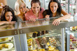 Women friends looking at cakes in cafe