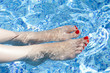 Sexy women legs splashing in tropical swimming pool