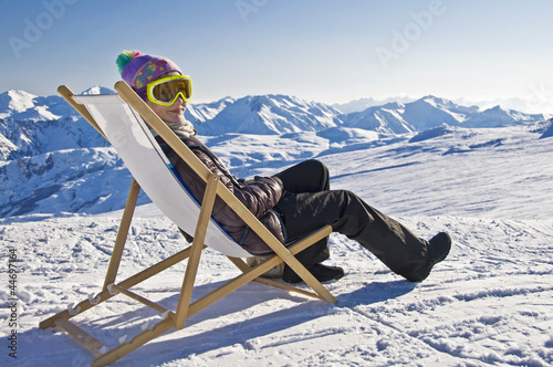 Foto: Jeune femme dans une chaise longue sur les pistes de ski - Alpes Jeune femme dans une chaise longue sur les pistes de ski - Alpes