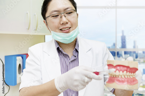 Photo: Dentist brushing dentures Dentist brushing dentures
