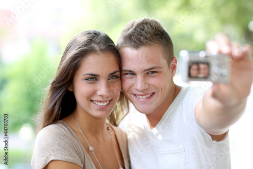 Photo: Cute young couple of lovers taking picture of themselves Cute young couple of lovers taking picture of themselves