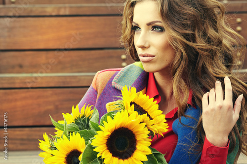 Photo: Fashion woman with sunflower at outdoor. Fashion woman with sunflower at outdoor.