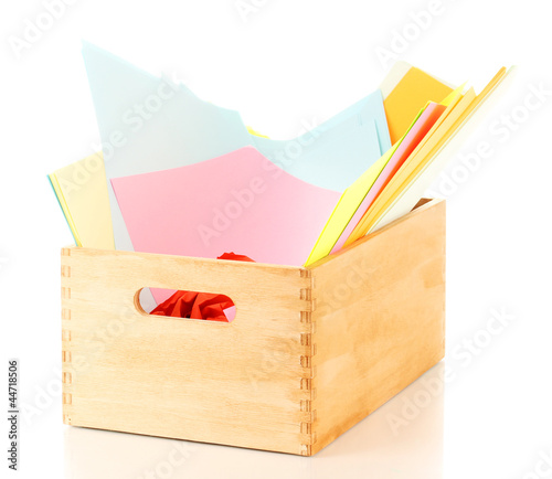 Photo: Wooden crate with colorful papers isolated on white Wooden crate with colorful papers isolated on white