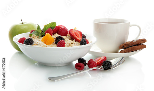 Photo: tasty oatmeal with berries and cup of tea, isolated on white tasty oatmeal with berries and cup of tea, isolated on white