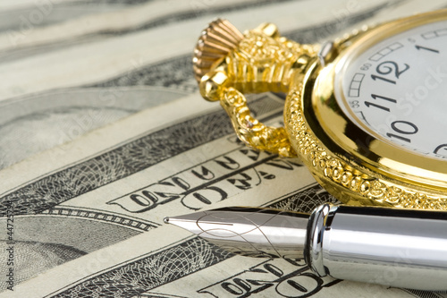 Photo: ink pen and watch on dollar banknotes ink pen and watch on dollar banknotes