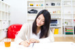 a young asian woman studying in the room