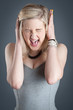 Photo: Portrait of screaming desperate blonde teenager girl on dark bac Portrait of screaming desperate blonde teenager girl on dark bac
