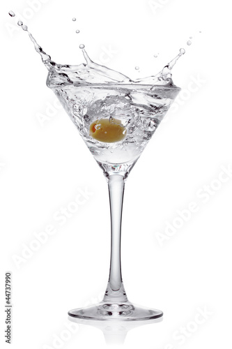Photo: Splash from olive in a glass of cocktail. Splash from olive in a glass of cocktail.