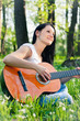 Young woman playing the guitar outdoors