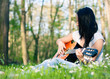 Young woman playing the guitar outdoors