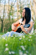 Young woman playing the guitar outdoors