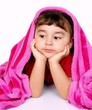 Little girl under pink blanket, on white background