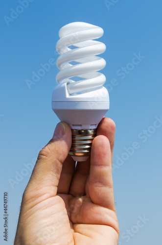 Photo: energy saving lamp in hand energy saving lamp in hand