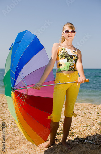Photo: Teenage girl carrying iridescent umbrella Teenage girl carrying iridescent umbrella