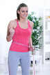 Happy, excited girl standing with measuring tape
