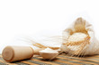 Flour and wheat grain with wooden spoon on a wooden table.