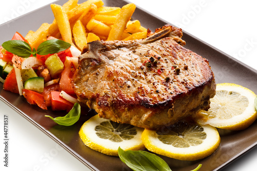 Photo: Grilled steaks, French fries and vegetables Grilled steaks, French fries and vegetables