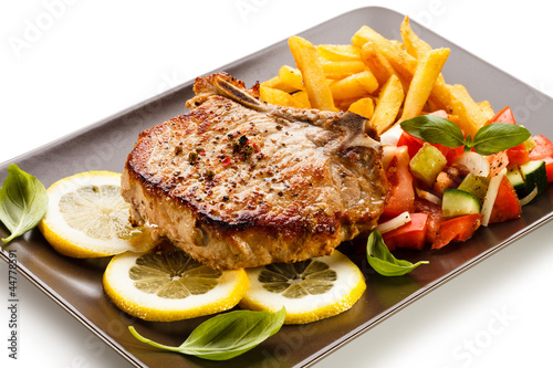 Foto: Grilled steaks, French fries and vegetables Grilled steaks, French fries and vegetables