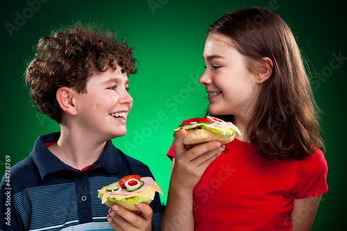 Photo: Kids eating big sandwiches Kids eating big sandwiches