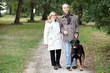 a old woman holding husband's arm in a park in autumn