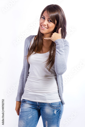 Photo: mujer joven feliz haciendo un gesto de llamada mujer joven feliz haciendo un gesto de llamada