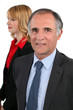 senior businessman and his young assistant posing