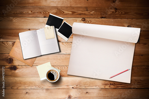 Photo: Workspace with coffee cup, instant photos, note paper and notebo Workspace with coffee cup, instant photos, note paper and notebo