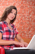 Woman using laptop with expression of astonishment