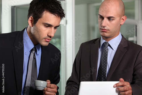 Foto: Businessmen looking at a laptop Businessmen looking at a laptop