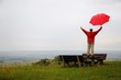 Man with red umbrella is happy in an autumnal landscape