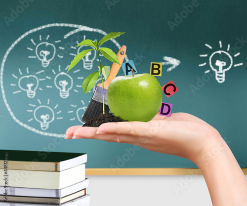 Photo: hand with green apple and educational ideas hand with green apple and educational ideas