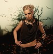 Woman against old spooky tree with birds over it