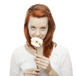 Foto: young beautiful red haired girl smelling on a flower young beautiful red haired girl smelling on a flower