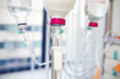 bottle with white drug and intravenous drip system in in hospita