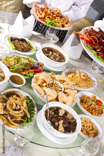 Photo: mixed Chinese food with chef holding some dishes mixed Chinese food with chef holding some dishes