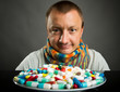 Man looking on plate full of pills