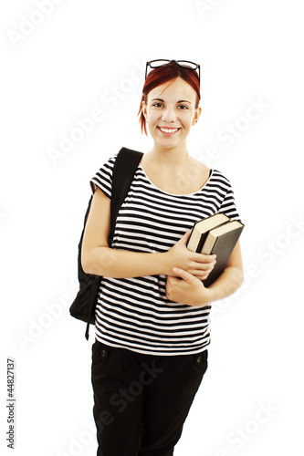 Photo: A smiling female student with a school bag holding a book A smiling female student with a school bag holding a book