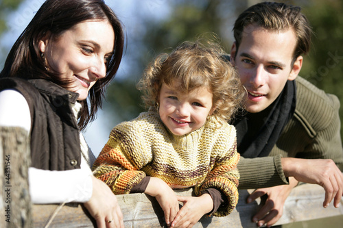 Photo: Young family leaning against fence Young family leaning against fence
