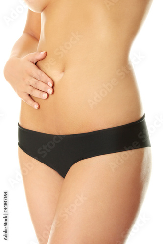 Photo: Fit young woman belly with hand on it Fit young woman belly with hand on it