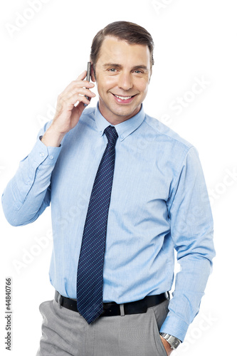 Photo: Business executive communicating over cellphone Business executive communicating over cellphone