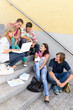 Students having fun with laptop school stairs