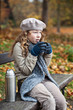 Photo: Girl in winter cloths drinking from flask cup Girl in winter cloths drinking from flask cup