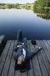 Young businessman relaxing on pier near lake