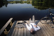 Young businessman relaxing on pier at lake with bicycle