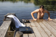 Young businessman coming out of lake water onto pier