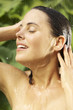 Young woman taking shower outdoors